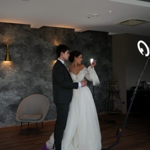 Boldog jegyespár videót készít a Selfie 360 forgó szelfigéppel, a menyasszony rámutat a kamerára